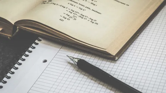 Math textbook and graph notebook with pencil